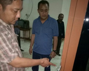 Petugas menunjukkan bekas gawang pintu rumah Soewandi yang disongkel pencuri.