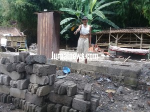 Foto: Sabiyanto saat menunjuk batako yang masih bisa dipakai. (Dok.rony).