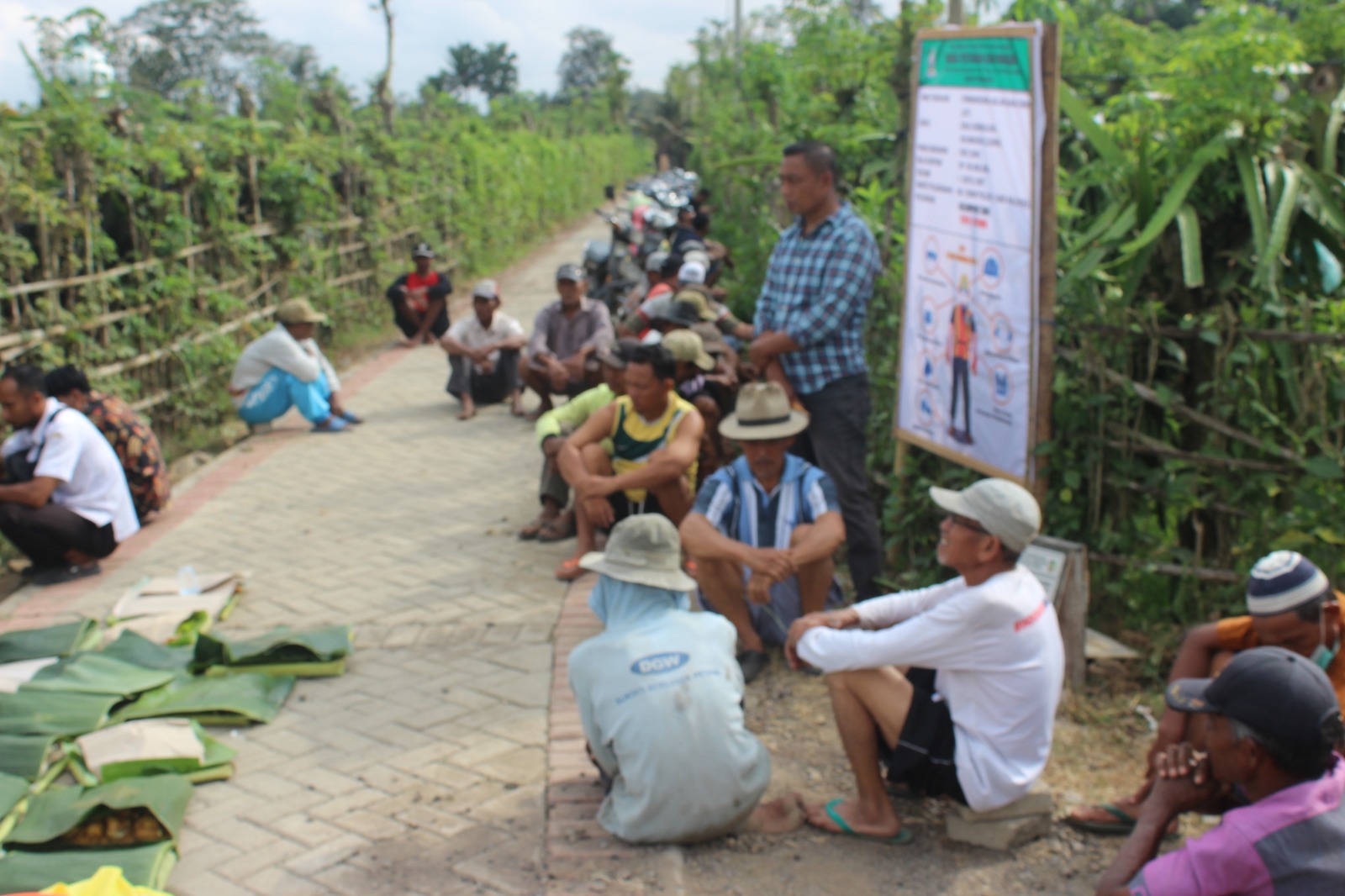 Foto : Warga tani bersiap siap mengelar selamatan paving dijalan yang baru selesai di paving. (Doc. Rony).