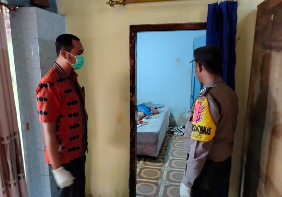 Korban dengan keadaan terlentang memakai sehelai kainhanduk, dan dua petugas dari kepolisan dan kesehatan siap siaga didepan kamar hotel. (Foto: Humas Polsek Gambiran).
